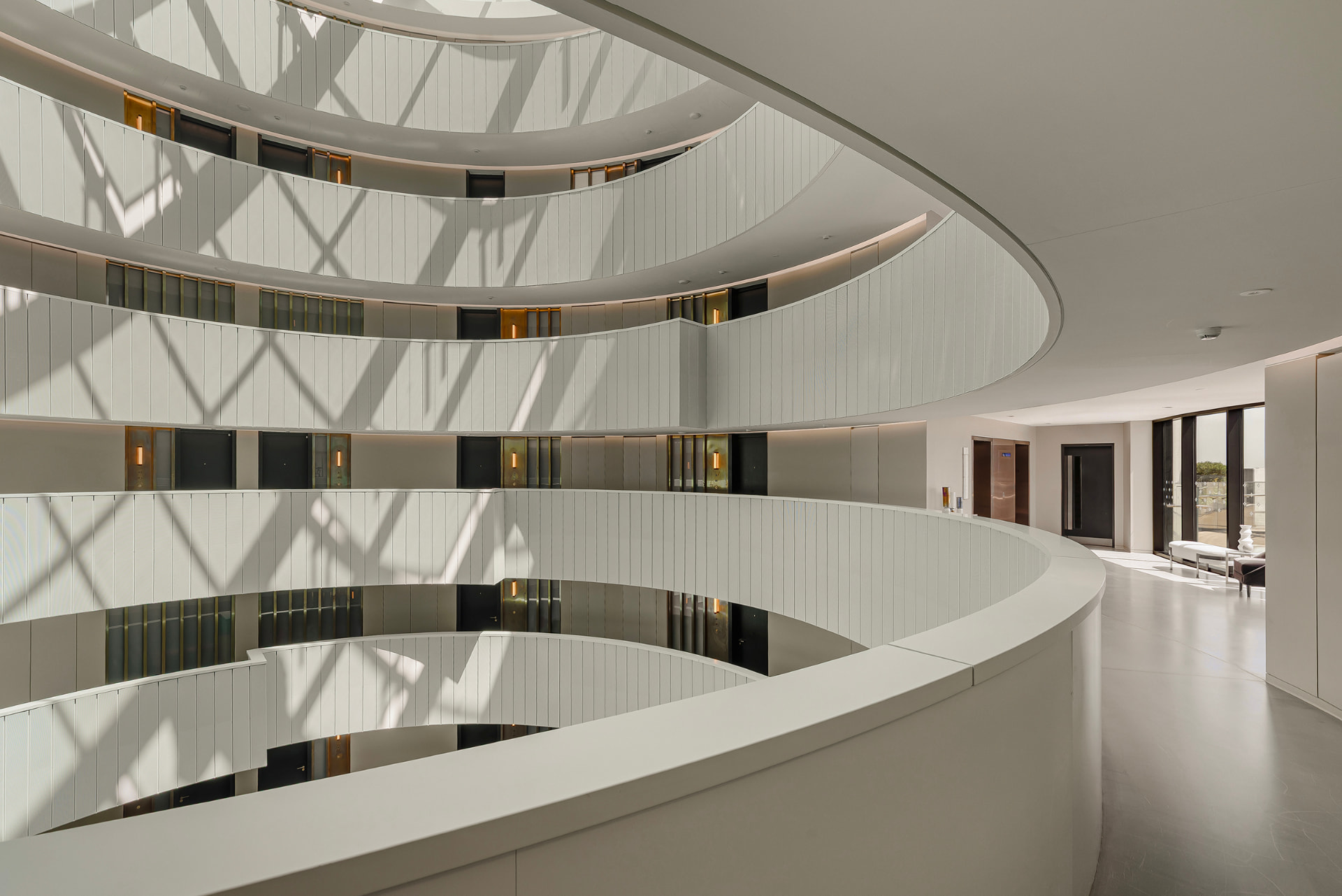Curved white balconies and daylight shadows inside the Gasholders Building, London